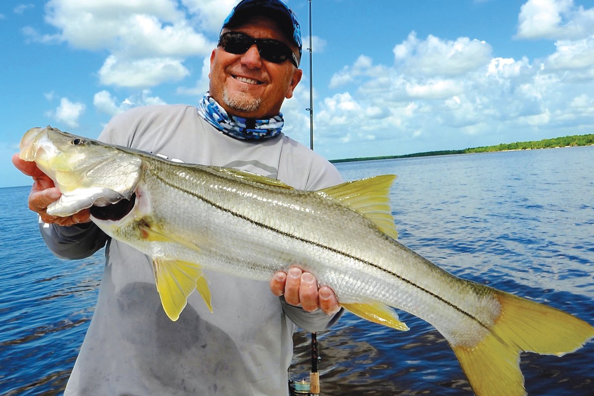 Angler displaying a freshly caught snook on Florida waters