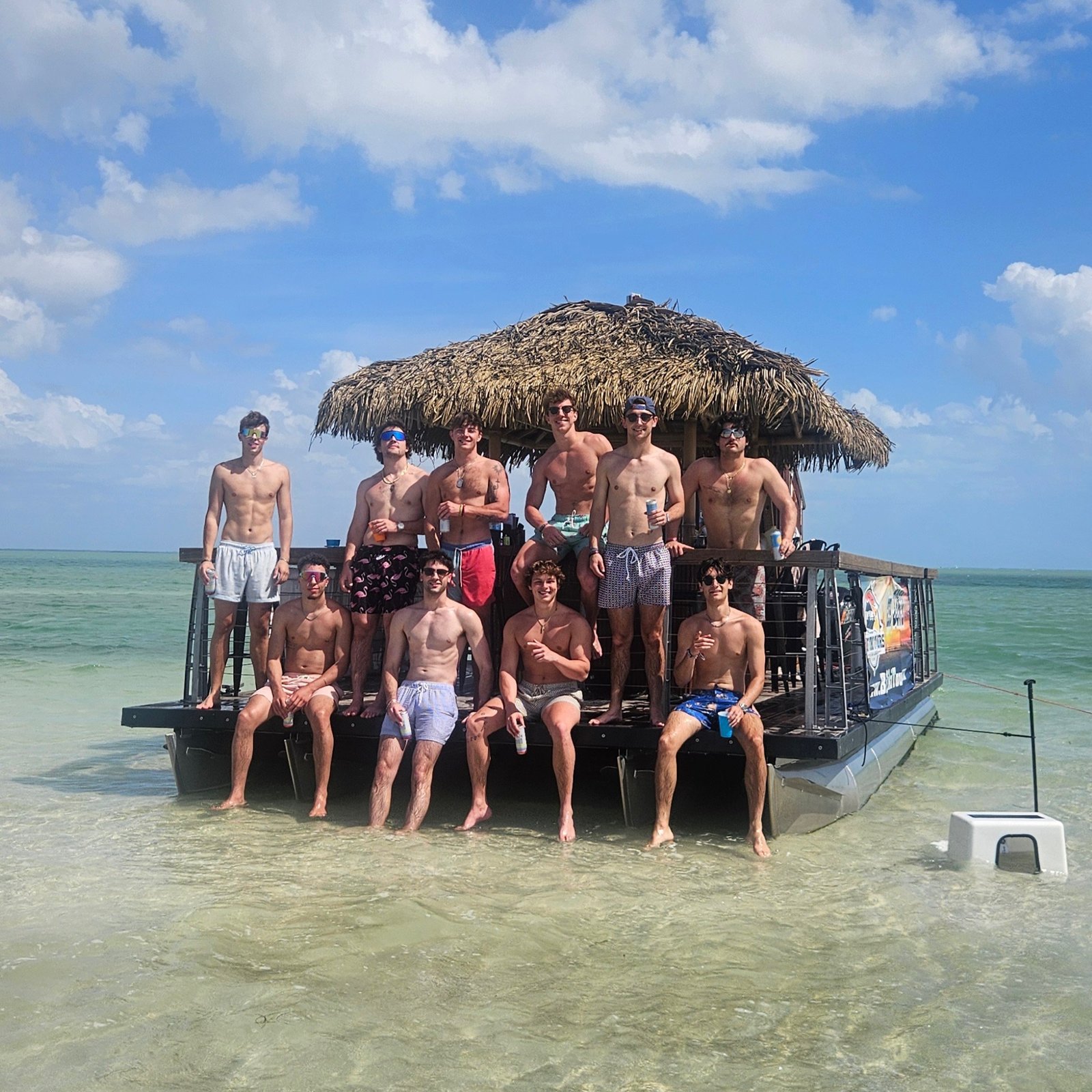 Friends enjoying a sandbar stop beside the Big Tiki Boat